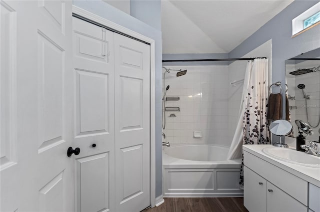 bathroom featuring shower / bathtub combination with curtain, vanity, hardwood / wood-style flooring, and vaulted ceiling