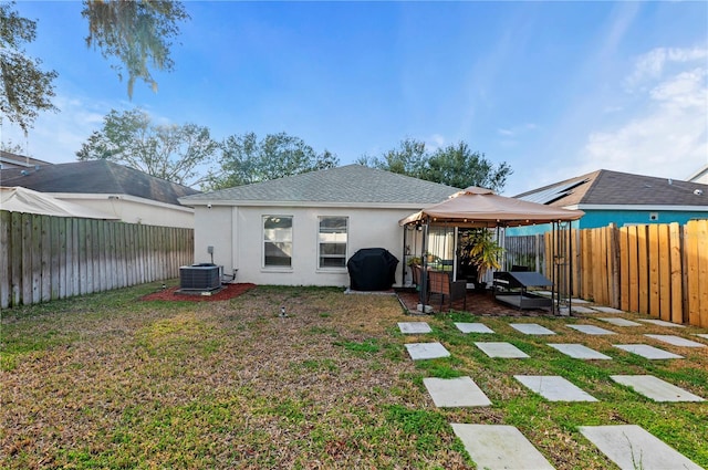 back of house featuring a gazebo, a yard, and central AC unit