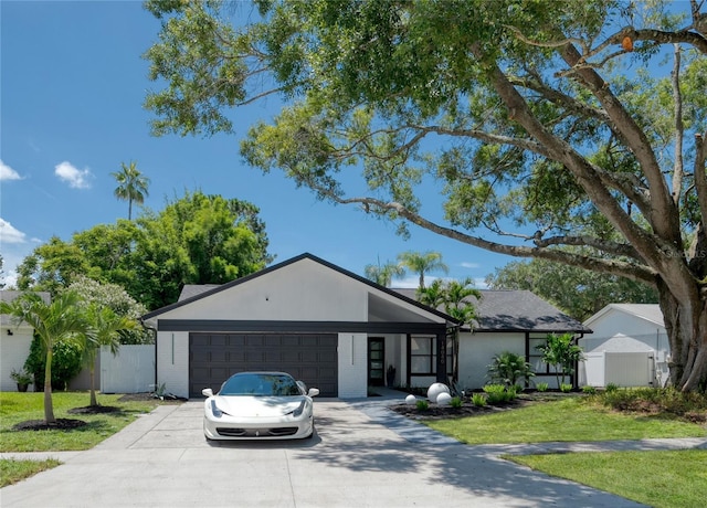 single story home featuring a garage and a front yard