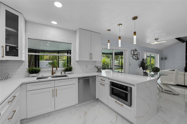 kitchen with white cabinetry, sink, backsplash, light stone counters, and stainless steel appliances