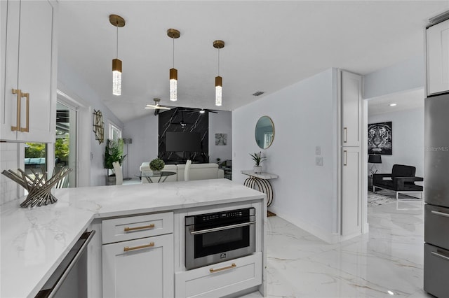 kitchen featuring white cabinetry, stainless steel appliances, light stone counters, and hanging light fixtures