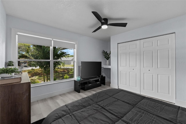 unfurnished bedroom featuring ceiling fan, light hardwood / wood-style floors, and a closet