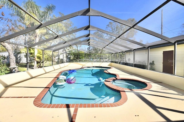 view of swimming pool featuring a lanai, a patio area, and an in ground hot tub