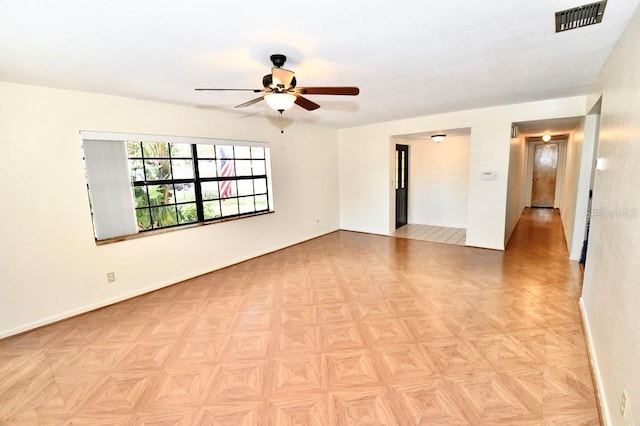 empty room featuring ceiling fan and light parquet floors