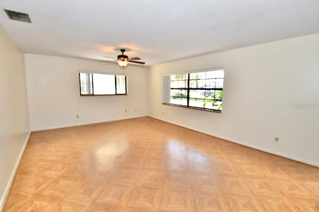 unfurnished room with ceiling fan and light parquet floors