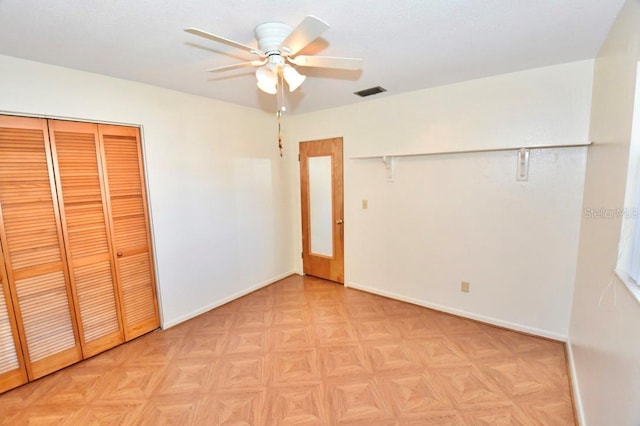 unfurnished bedroom featuring ceiling fan, a closet, and light parquet flooring