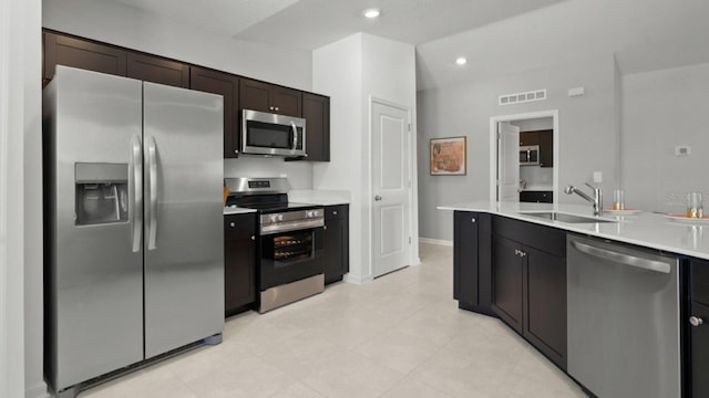 kitchen featuring appliances with stainless steel finishes, sink, and dark brown cabinets