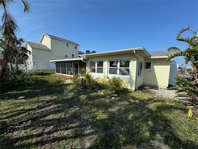 back of house featuring a sunroom and a yard