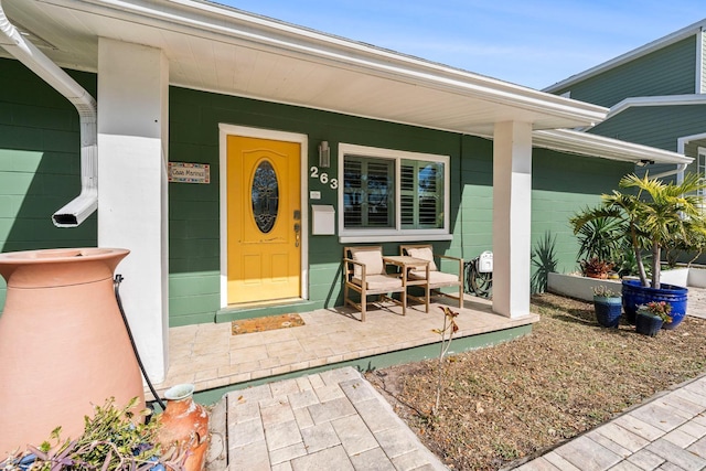 view of exterior entry featuring covered porch