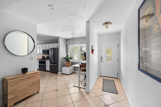 tiled entrance foyer featuring a textured ceiling