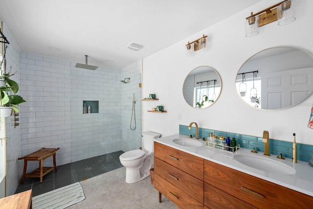 bathroom featuring tile walls, tile patterned flooring, vanity, tiled shower, and toilet