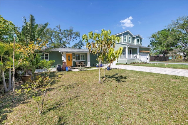 view of front of home featuring a front yard, covered porch, and driveway