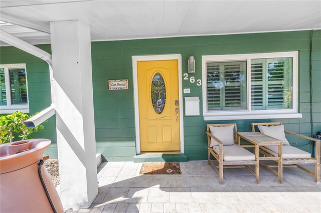 doorway to property featuring covered porch and concrete block siding