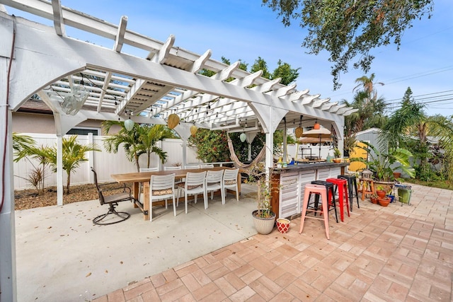 view of patio / terrace featuring a pergola, outdoor dining area, outdoor dry bar, and fence