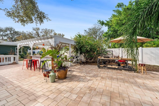 view of patio featuring a pergola, outdoor dining area, and fence