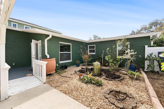 exterior space with concrete block siding and an outdoor fire pit