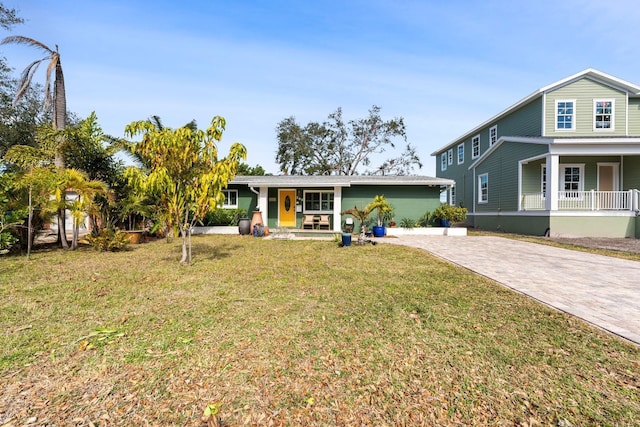 view of front of property with a front yard, covered porch, and decorative driveway