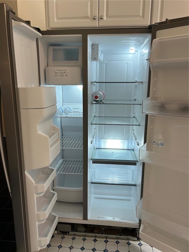 room details with refrigerator and white cabinets