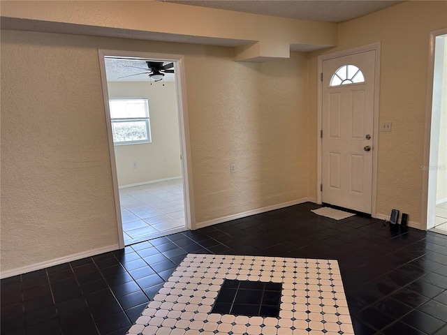 tiled foyer featuring ceiling fan