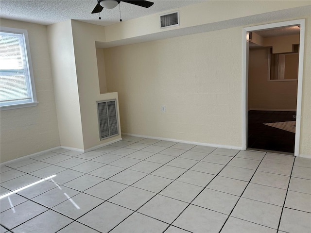 unfurnished living room with light tile patterned flooring, ceiling fan, and a textured ceiling