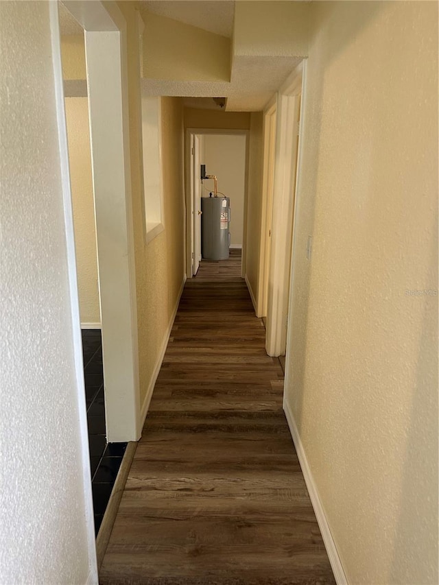 hallway with dark wood-type flooring and water heater