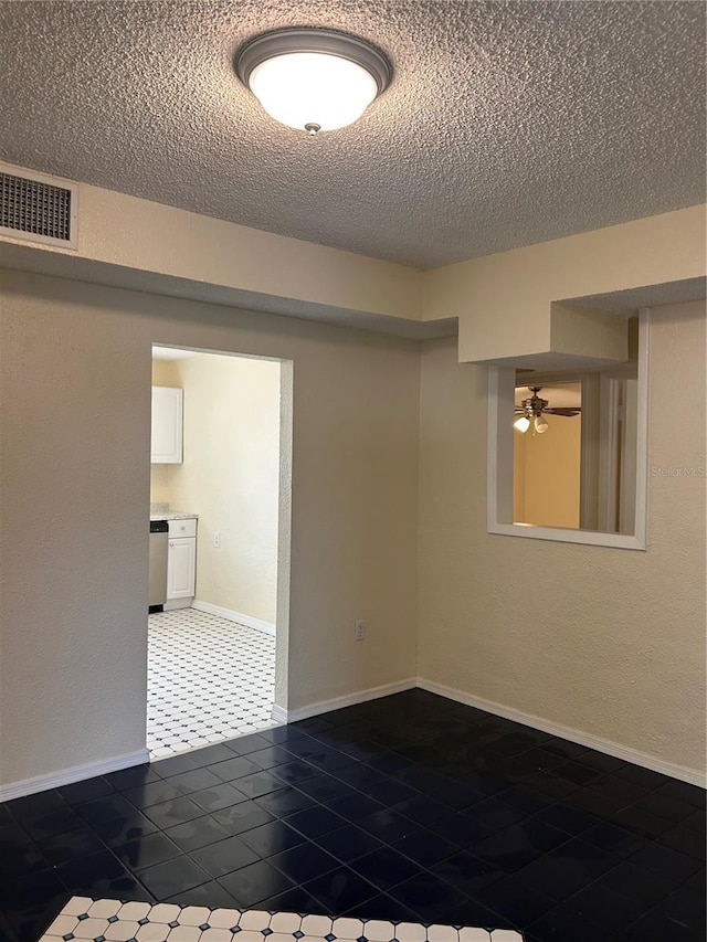 empty room with a textured ceiling and ceiling fan