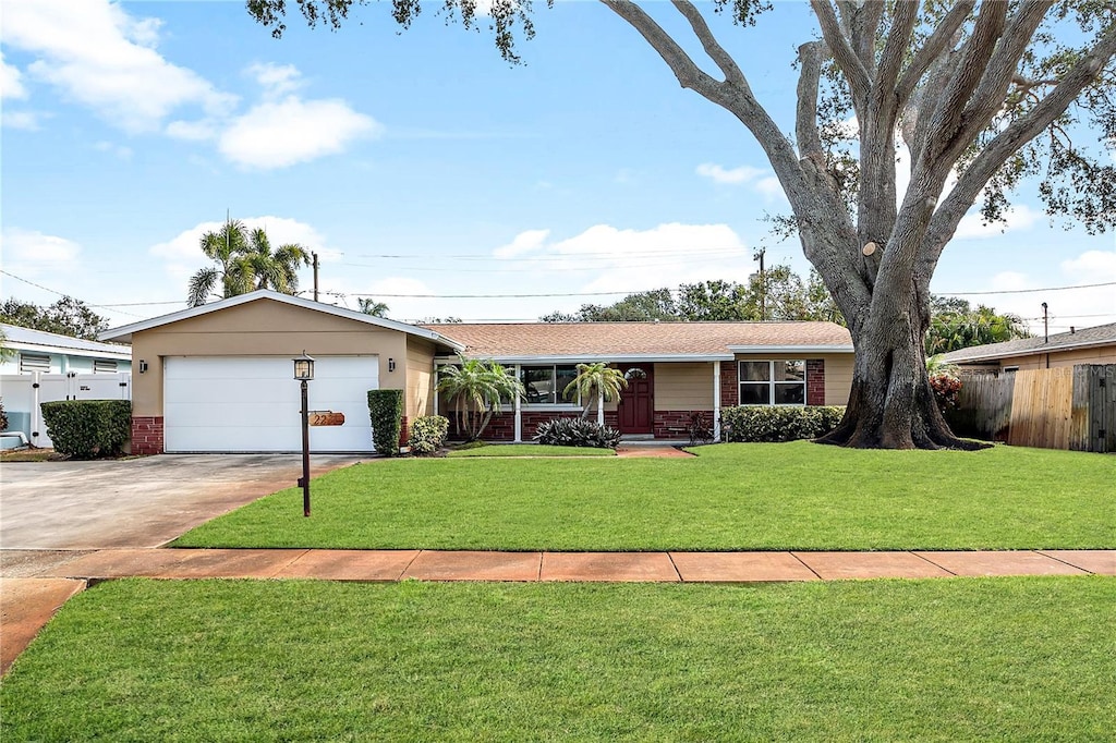 ranch-style home featuring a garage and a front lawn