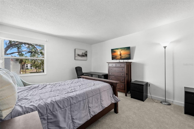 bedroom with light colored carpet and a textured ceiling