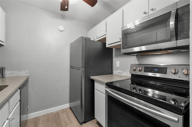 kitchen featuring ceiling fan, stainless steel appliances, white cabinets, and light wood-type flooring