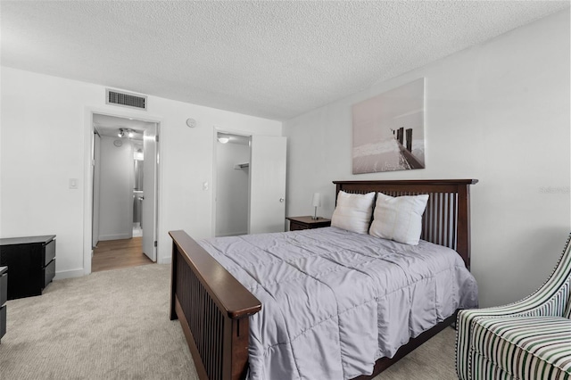 bedroom with light carpet and a textured ceiling