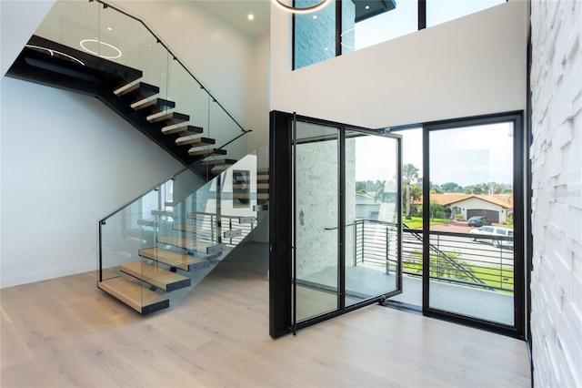 staircase featuring a towering ceiling and hardwood / wood-style floors