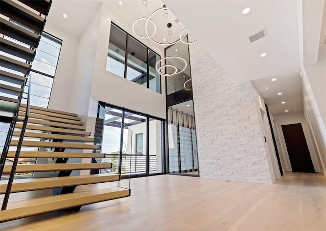 stairs featuring wood-type flooring and a high ceiling