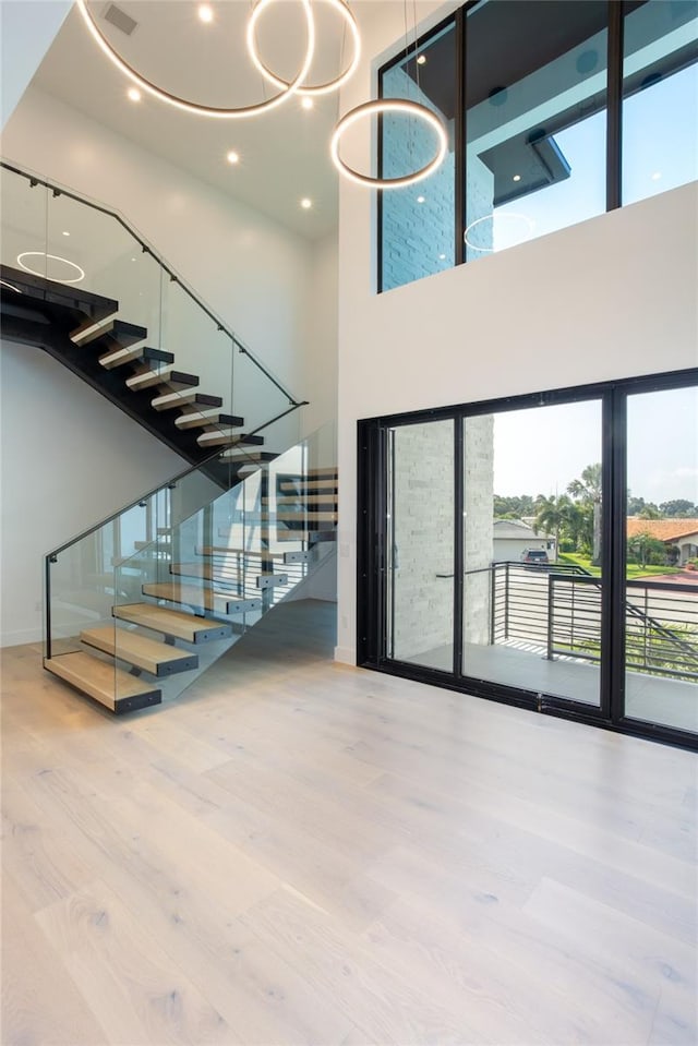 entryway featuring a towering ceiling and light hardwood / wood-style floors