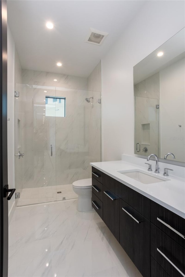 bathroom with vanity, toilet, and a shower with shower door