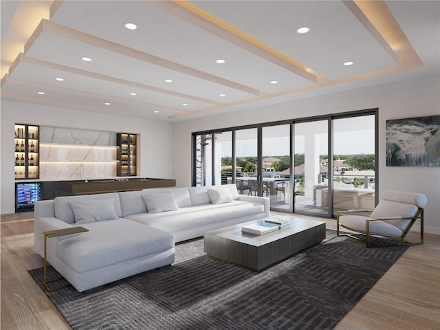 living room featuring a raised ceiling, indoor bar, and hardwood / wood-style floors