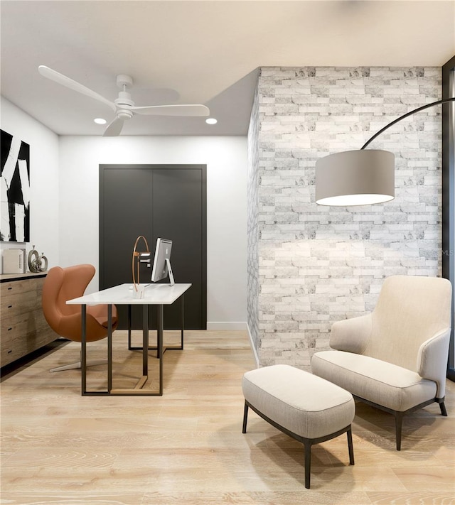 living area with light hardwood / wood-style floors and ceiling fan