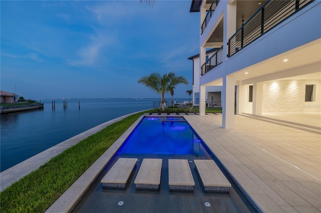 view of pool with a patio and a water view