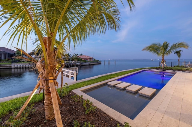 view of swimming pool with a water view and a hot tub