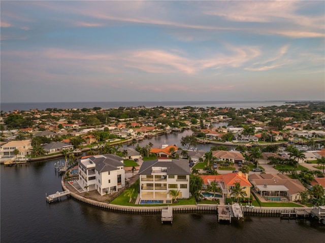 aerial view at dusk featuring a water view