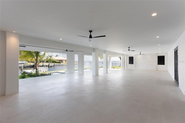 interior space with a water view and ceiling fan