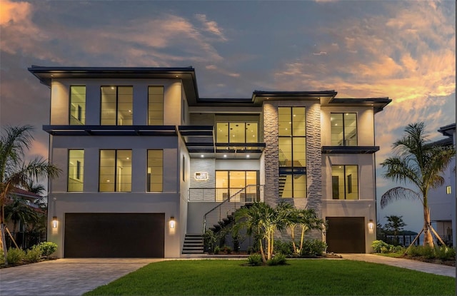 modern home featuring stucco siding, decorative driveway, and an attached garage