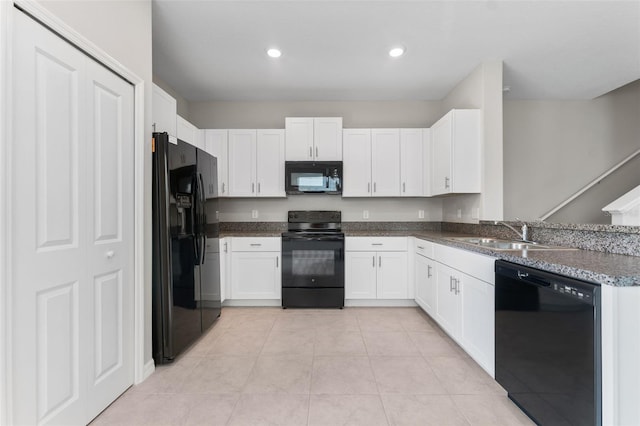 kitchen featuring sink, black appliances, white cabinets, and light tile patterned flooring