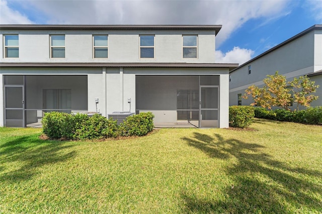 back of property with a sunroom, a lawn, and central air condition unit