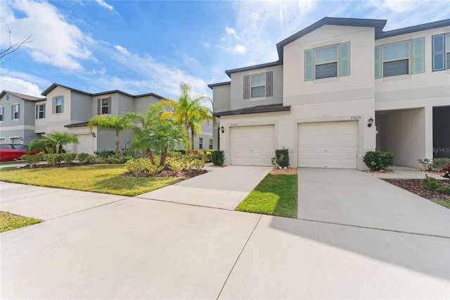 townhome / multi-family property featuring a garage and a front lawn