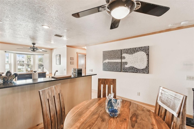 dining room featuring crown molding and a textured ceiling