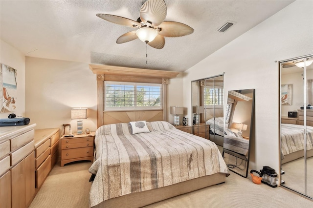 carpeted bedroom with multiple windows, lofted ceiling, and a textured ceiling