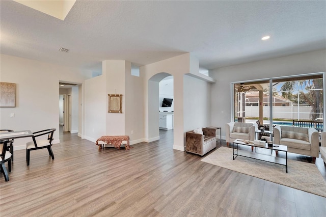 living room featuring a textured ceiling and light hardwood / wood-style floors