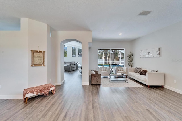 living room with light hardwood / wood-style floors and a textured ceiling