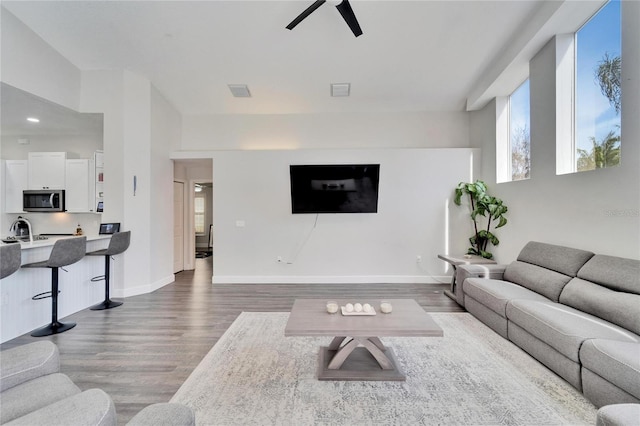 living room with dark wood-type flooring and ceiling fan