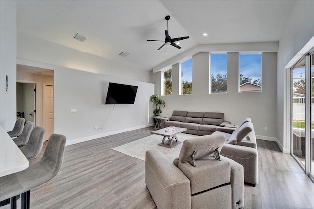 living room with wood-type flooring, lofted ceiling, a wealth of natural light, and ceiling fan